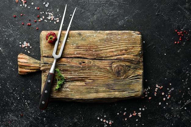 Ancienne planche à découper de cuisine sur fond sombre. Vue de dessus. Espace libre pour votre texte.