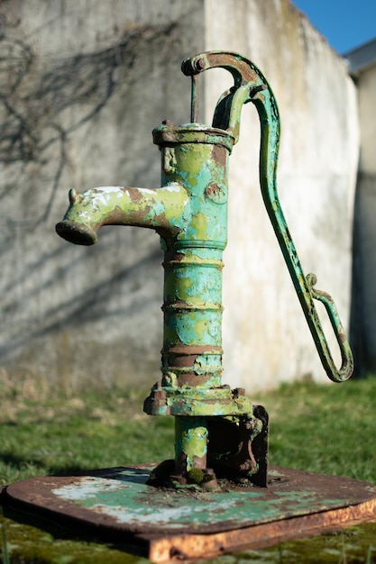 Ancienne pompe à eau manuelle sur un puits dans le jardin arrosant et économisant de l'eau en milieu rural