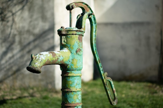 Ancienne pompe à eau manuelle sur un puits dans le jardin arrosant et économisant de l'eau en milieu rural