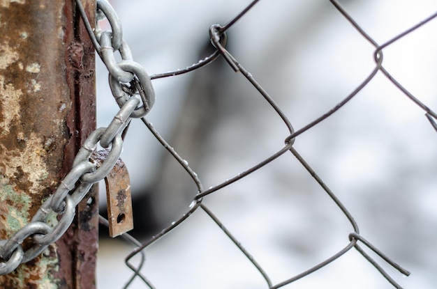 L'ancienne porte en fer est verrouillée avec une chaîne Introduction par effraction dans une propriété privée Zone secrète fermée