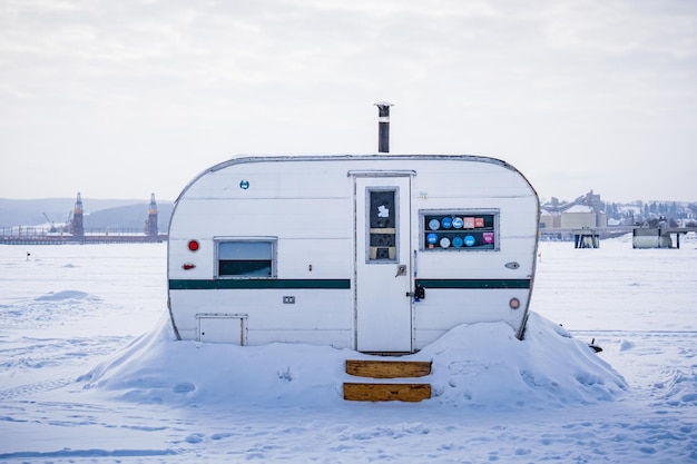 Ancienne remorque utilisée comme cabane de pêche blanche sur le fjord gelé du Saguenay à la Baie, Québec (Canada)