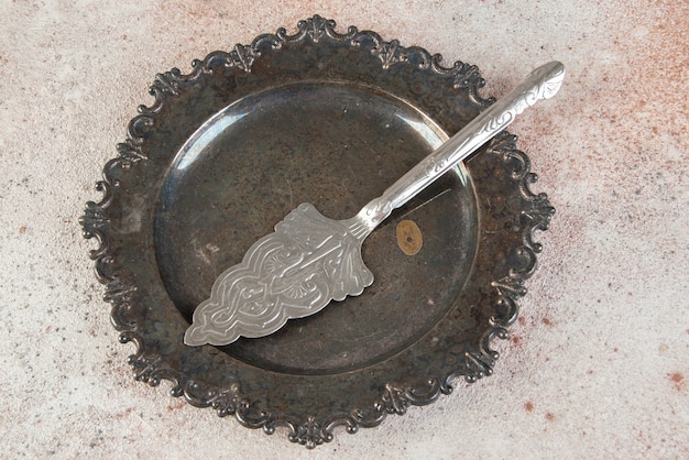 Ancienne spatule à gâteau en métal en plaque antique sur table en béton.