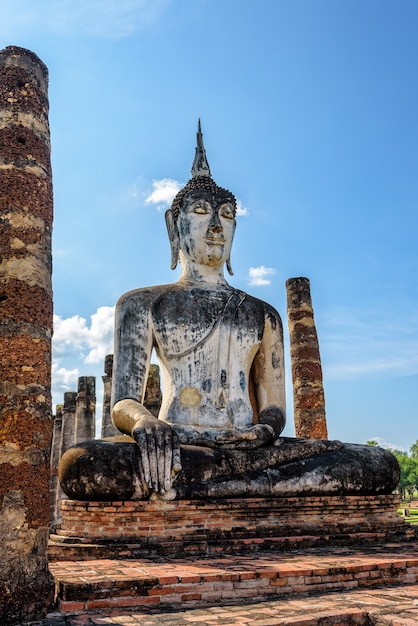Ancienne statue de Bouddha assise parmi les ruines sous le ciel lumineux du temple Wat Maha That dans le parc historique de Sukhothai est une vieille ville et une attraction touristique célèbre de la province de Sukhothai, en Thaïlande