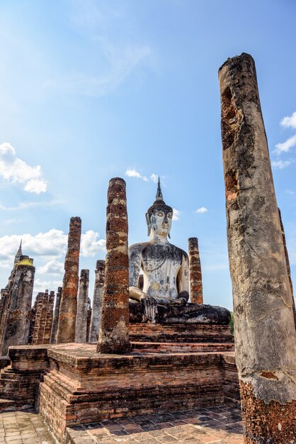 Ancienne statue de Bouddha assise parmi les ruines sous le ciel lumineux du temple Wat Maha That dans le parc historique de Sukhothai est une vieille ville et une attraction touristique célèbre de la province de Sukhothai, en Thaïlande