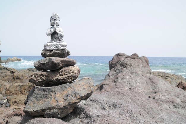 Une ancienne statue de Bouddha gris près de l'océan