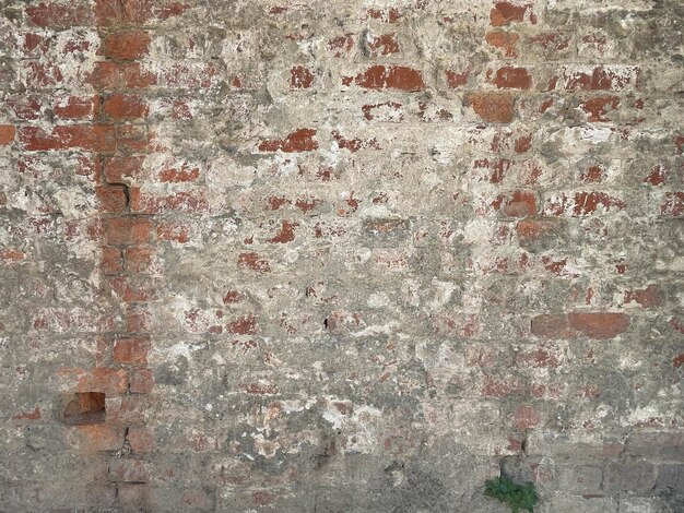 Ancienne texture de mur de brique rouge grunge avec photo d'arrière-plan en plâtre gris sale.