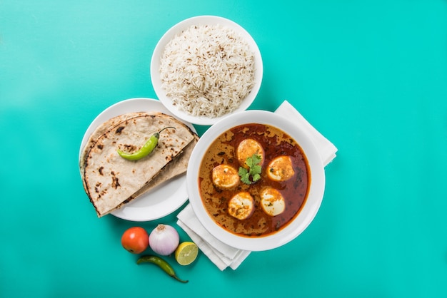 Anda Curry ou Egg masala sauce, cuisine indienne épicée ou recette, servie avec du riz Jeera, roti ou naan, mise au point sélective. Sur un dessus de table coloré ou en bois