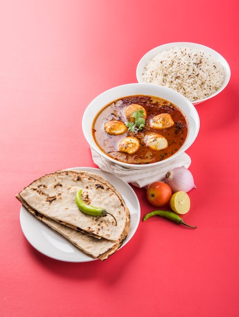 Anda Curry ou Egg masala sauce, cuisine indienne épicée ou recette, servie avec du riz Jeera, roti ou naan, mise au point sélective. Sur un dessus de table coloré ou en bois