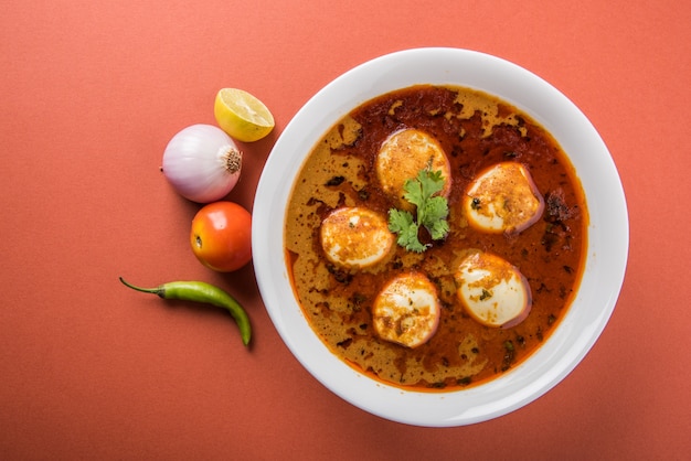 Anda Curry ou Egg masala sauce, cuisine indienne épicée ou recette, servie avec du riz Jeera, roti ou naan, mise au point sélective. Sur un dessus de table coloré ou en bois