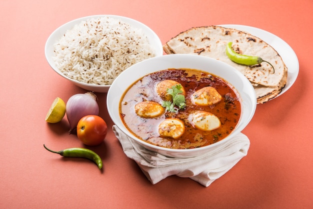 Anda Curry ou Egg masala sauce, cuisine indienne épicée ou recette, servie avec du riz Jeera, roti ou naan, mise au point sélective. Sur un dessus de table coloré ou en bois