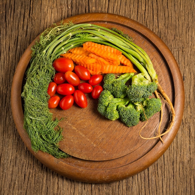 Photo aneth. bébé tomates. carotte. brocoli. sur vieux hachage en bois sur une vieille cuisine en bois