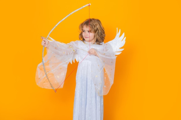 Ange enfant tire une flèche d'amour d'un arc le jour de la saint valentin enfant au costume d'ange enfant avec ange gagne