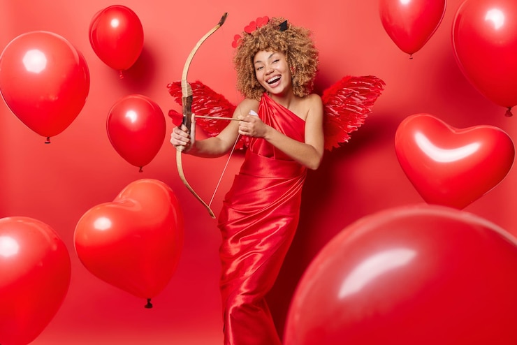 Photo l'ange féminin aux cheveux bouclés tire avec l'arc.