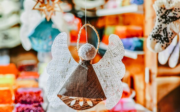 Ange en lin fait main suspendu au marché de Noël du vieux Riga, Lettonie. L'Europe en hiver. Noël de rue et salon des fêtes. Décoration de l'Avent et stands d'objets d'artisanat sur le bazar