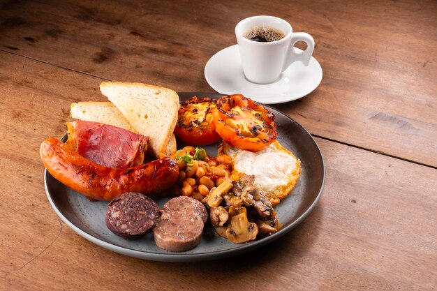 Anglais, irlandais, britannique, plat de petit déjeuner avec beaucoup de protéines, haricots sucrés, saucisses, bacon, œufs et une tasse de champignons au café.