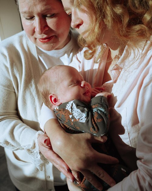 Photo angle élevé d'une femme tenant un bébé avec sa mère