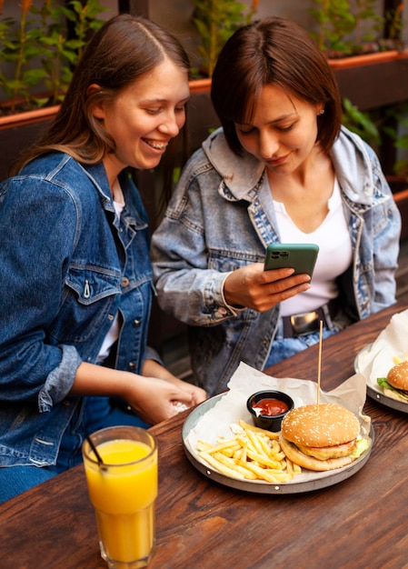 Photo angle élevé de femmes prenant une photo de leur nourriture