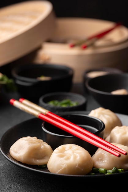 Angle élevé de plat asiatique traditionnel avec des baguettes et des boulettes sur plaque