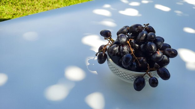 Angle élevé, raisins violets dans un bol avec tige