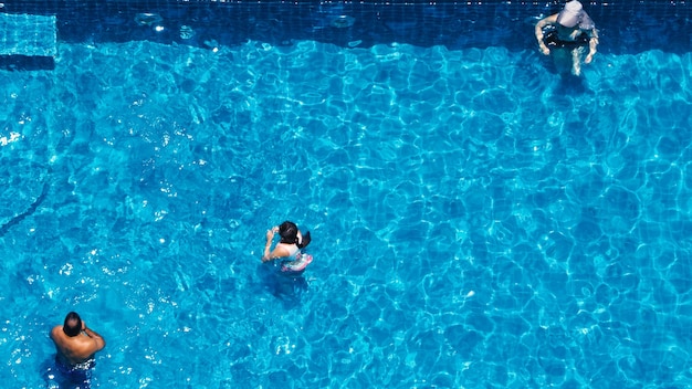 Angle de vue de dessus de piscine dont l'eau claire de couleur bleue et la lumière du soleil se reflètent sur la texture de la surface