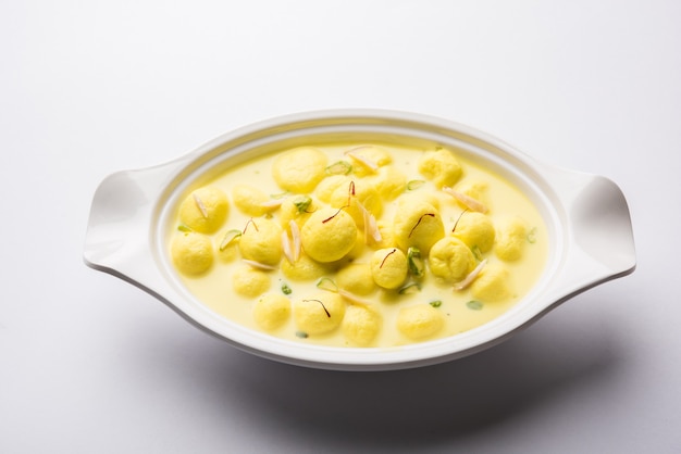 Angoori Rasmalai est un dessert indien sucré avec des fruits secs et des garnitures au safran, servi dans un bol sur fond de mauvaise humeur. mise au point sélective