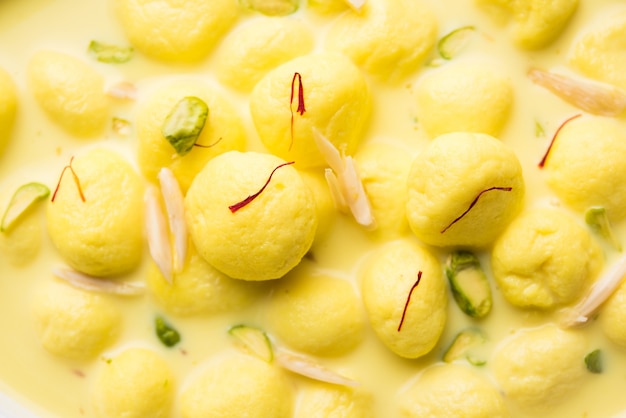 Angoori Rasmalai est un dessert indien sucré avec des fruits secs et des garnitures au safran, servi dans un bol sur fond de mauvaise humeur. mise au point sélective