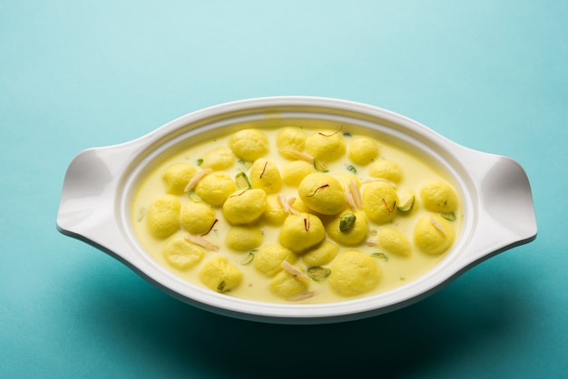 Angoori Rasmalai est un dessert indien sucré avec des fruits secs et des garnitures au safran, servi dans un bol sur fond de mauvaise humeur. mise au point sélective