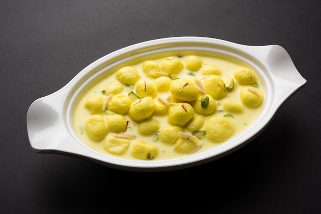 Angoori Rasmalai est un dessert indien sucré avec des fruits secs et des garnitures au safran, servi dans un bol sur fond de mauvaise humeur. mise au point sélective