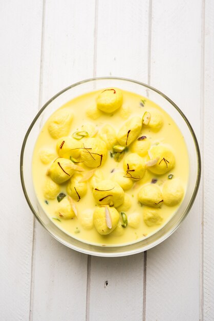 Angoori Rasmalai est un dessert indien sucré avec des fruits secs et des garnitures au safran, servi dans un bol sur fond de mauvaise humeur. mise au point sélective