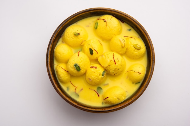 Angoori Rasmalai est un dessert indien sucré avec des fruits secs et des garnitures au safran, servi dans un bol sur fond de mauvaise humeur. mise au point sélective