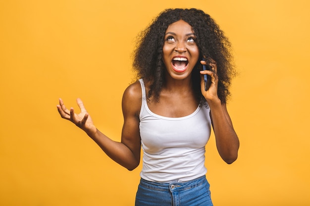 Angry mixed race black african american woman criant dans le téléphone mobile