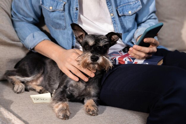 Un animal de compagnie allongé sur un canapé beige un morceau de papier avec le mot chien écrit à côté