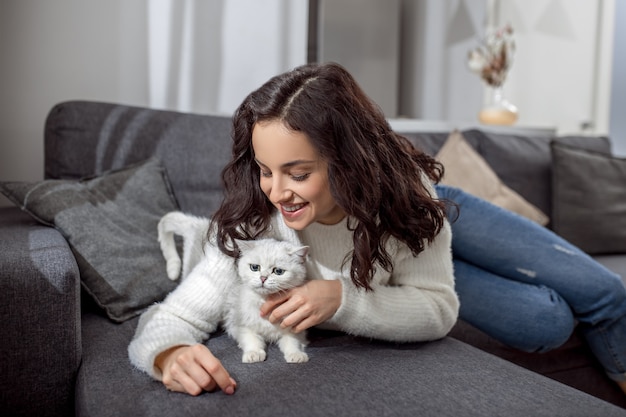 Avec un animal de compagnie. Jolie jeune femme passant le week-end à la maison et se sentant en paix