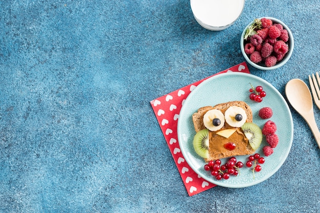 Animal drôle de petit déjeuner fait face à des toasts avec des tartinades