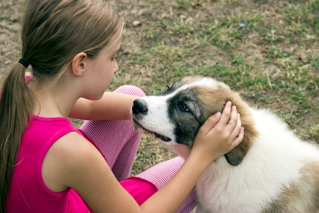 Animal love.Mignonne petite fille dans le domaine caresse son adorable chien