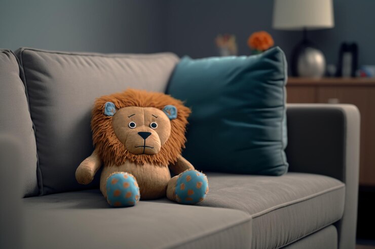 Photo un animal en peluche est assis sur un canapé avec un oreiller bleu qui dit "lion" dessus.