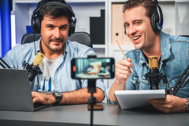 Photo l'animateur de la chaîne de radiodiffuseur créatif vivant par smartphone avec l'invité sellable