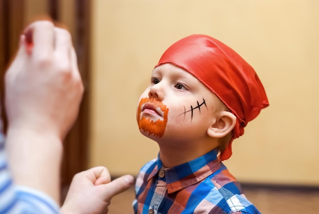 L'animateur fait de la peinture pirate sur le visage d'un tout-petit lors d'une fête d'anniversaire pour enfants