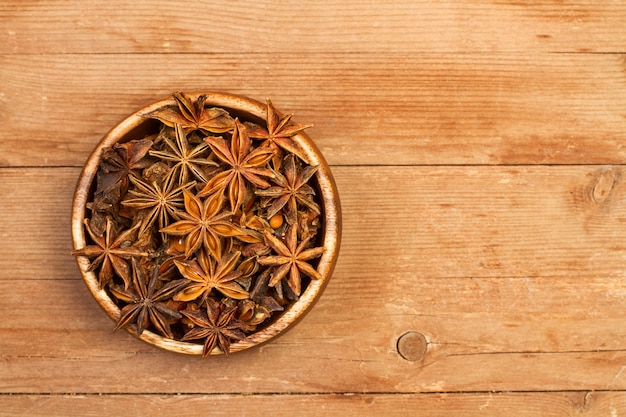 L'anis étoilé dans un bol en bois sur une table en bois rustique