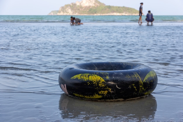 Photo un anneau de bain noir sur une plage de sable fin