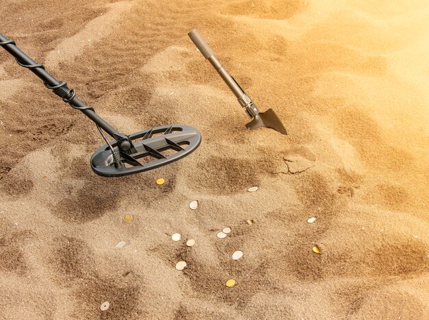 L'anneau du détecteur de métaux et la pelle sur le sable