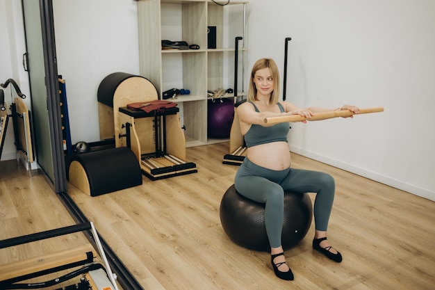 Anneau magique d'exercice de pilates de femme enceinte avec le fitball