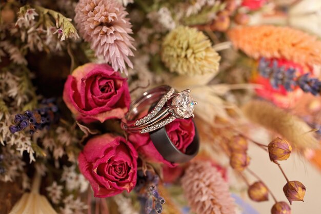 Photo anneau de mariage en diamant avec bande de mariage et bouquet de fleurs sauvages séchées parfumées boho micro mariage