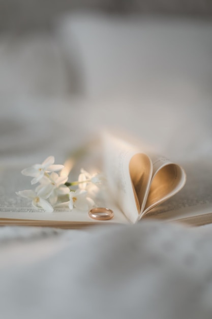 Anneau de proposition et un livre avec des feuilles pliées en forme de coeur Wedding Love Valentines Day concept
