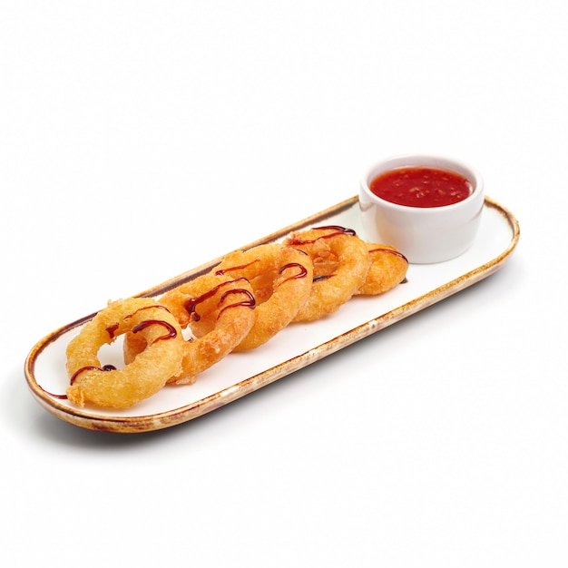 Anneaux de calamars croustillants frits caramari panés avec sauce rouge sur fond blanc Pour le menu du restaurant Assaisonnement pour sushi japonais traditionnel Alimentation saine