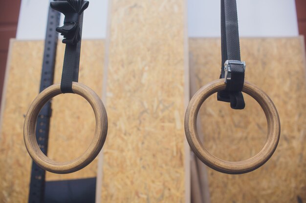 Anneaux de gymnaste en bois traditionnel suspendus à l'intérieur.