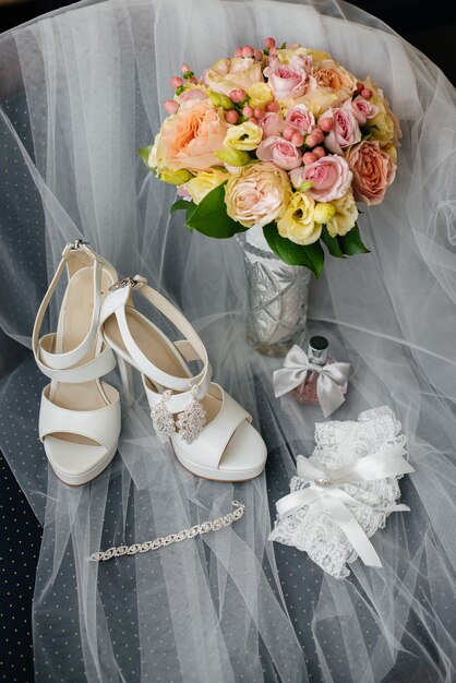 Photo anneaux de mariage et autres accessoires en gros plan lors de la réunion de la mariée. mariage.