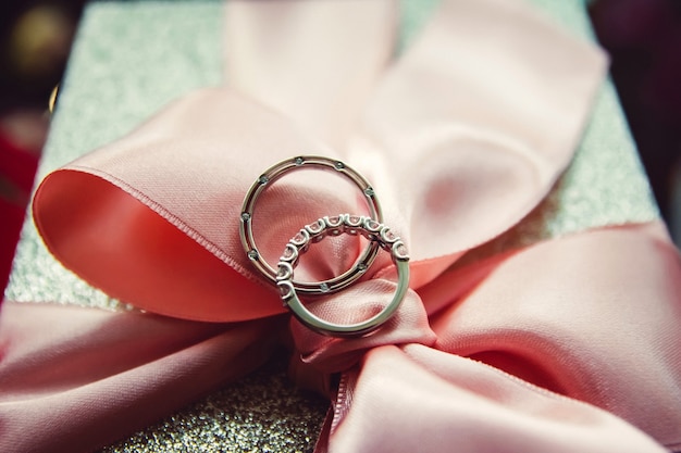 Anneaux de mariage. bijoux en or blanc et jaune. Bague de mariage sur ruban de satin. dentelle blanche.