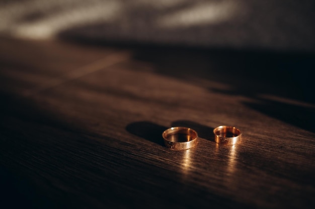 Photo anneaux de mariage sur une boîte en bois avec des ombres de feuilles anneau de mariage photo de haute qualité