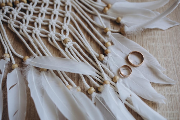 Anneaux de mariage sur une boîte en bois avec des ombres de feuilles